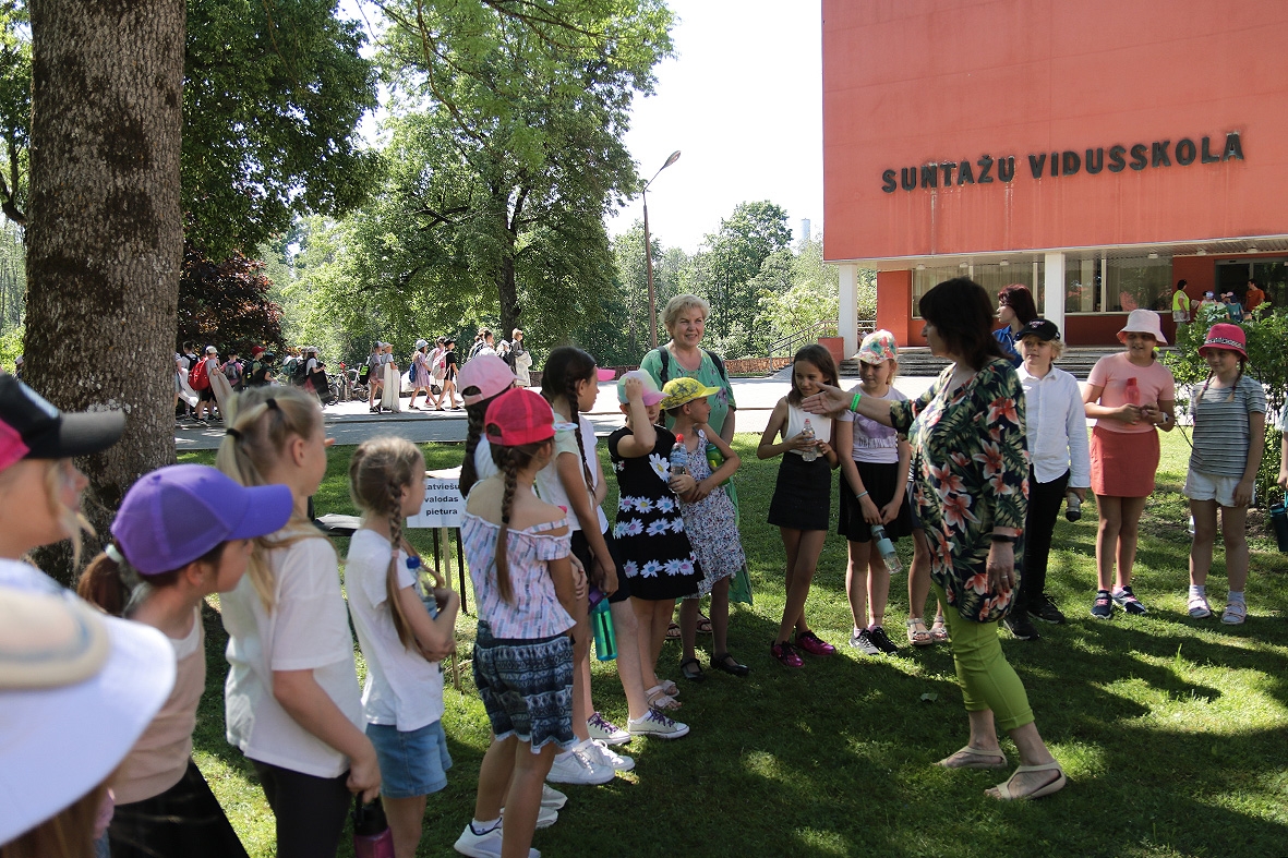 Bērni stāv pie Suntažu vidusskolas pasākumā Sadziedāsim Suntažos! 24.05.2024.