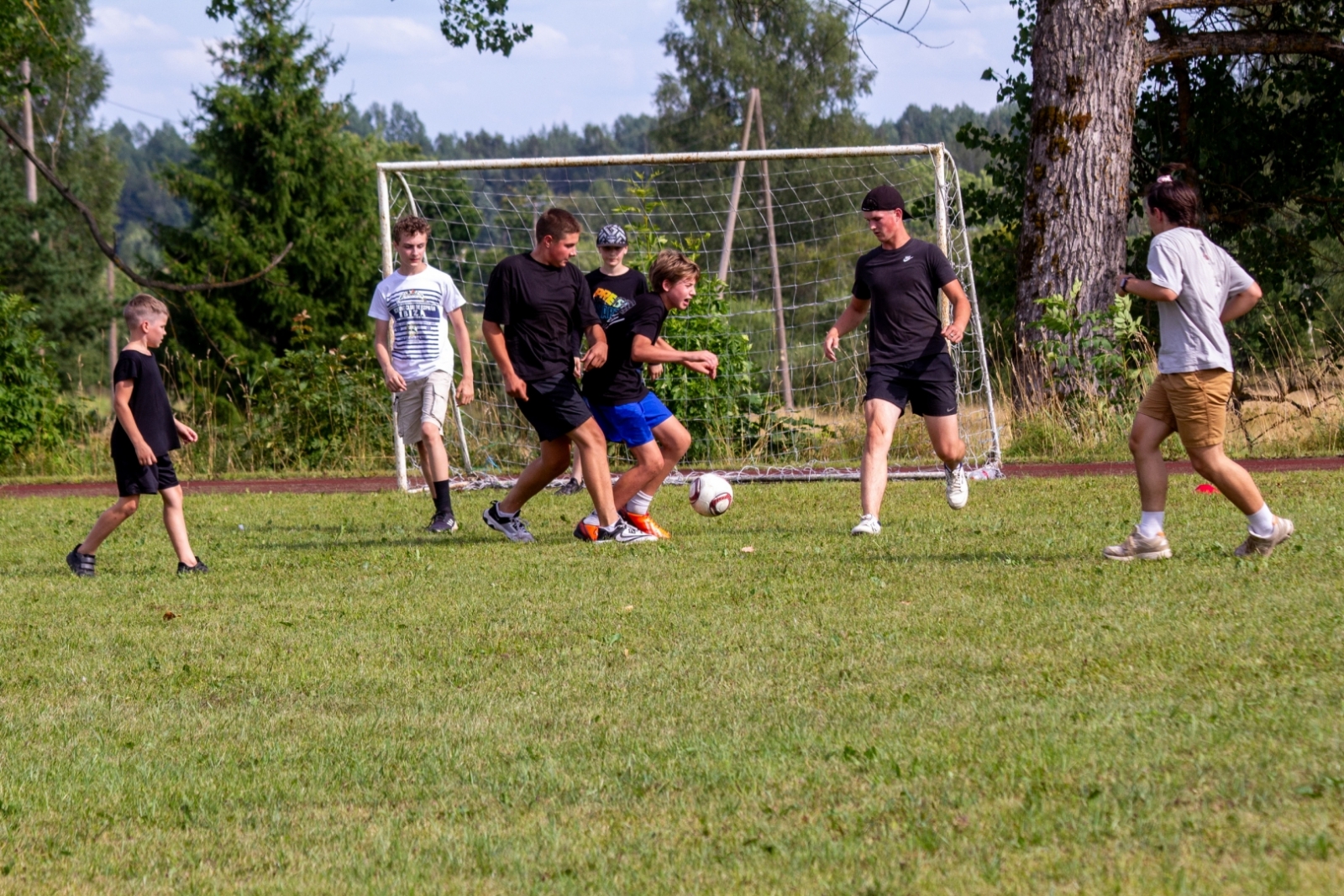 JAunieši baltos un melnos t-kreklos spēlē futbolu Taurupes pagasta svētkos 07.2024.