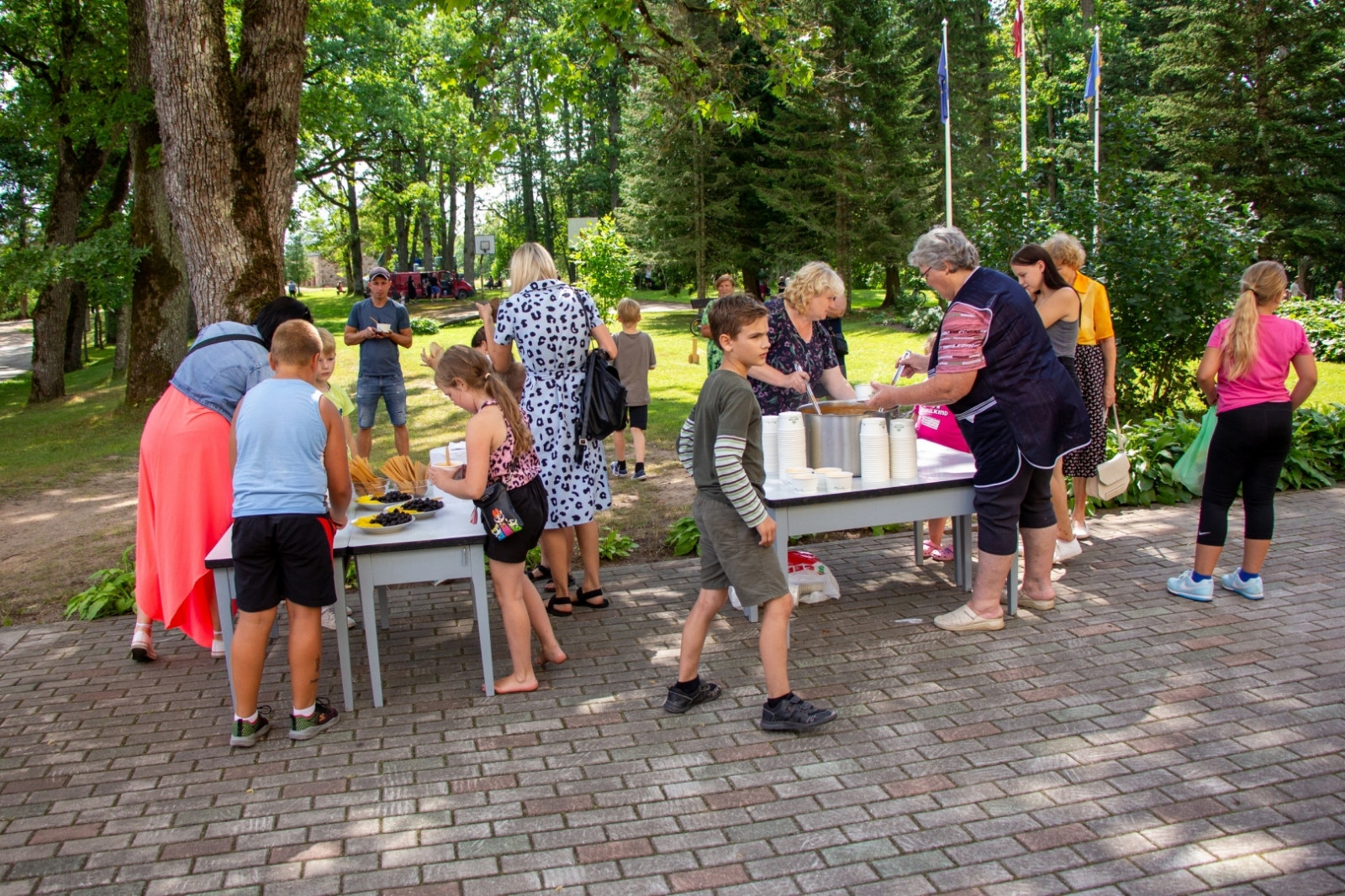 Iedzīvotāji darbojas pie galdiem Taurupes pagasta svētkos 07.2024.